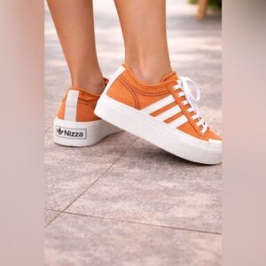 Adidias EUC Nizza low top platform
In orange canvas w/rubber toe
Woman’s size 8